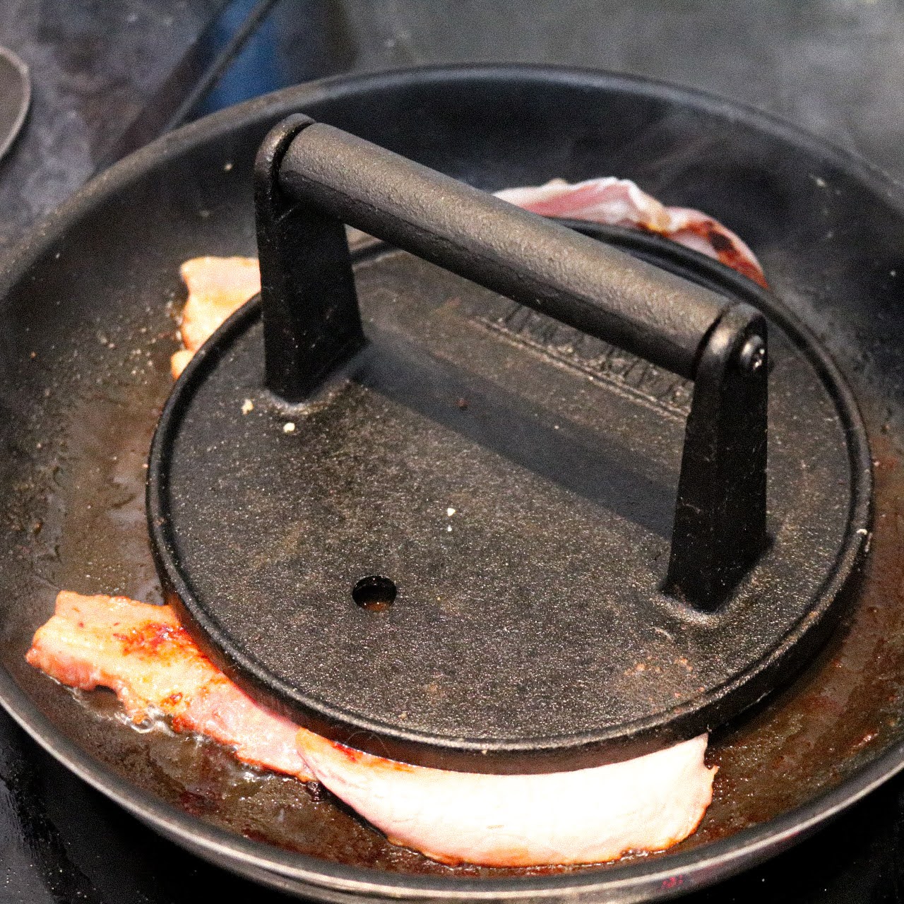 bacon cooking using a bacon weight